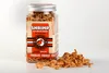 A clear studio shot of a jar of freeze-dried shrimp treats for cats and dogs, with some treats spilled in front of the jar. Produktbild-Vorschau