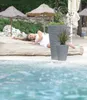 A woman is lying on a log on a beach next to two planters. Náhľad obrázku produktu