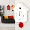 A living room scene with a black sofa, colorful pillows, and a white cuckoo clock. Anteprima dell’immagine prodotto