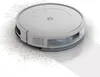 A robot vacuum cleaner is shown from a diagonal angle, cleaning up dust. Voir les images du produit