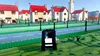A LEGO-style car driving on a road in a LEGO town. Produktbild-Vorschau