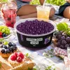 Schale mit Popping Boba Traube umgeben von frischen Weintrauben und Kraeutern Podgląd zdjęcia produktu