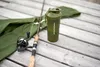 A fishing rod and a green shaker bottle are placed on a wooden deck. Voir les images du produit