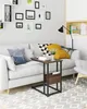 A living room scene with a sofa, side table, and wall decor. Produktbild-Vorschau