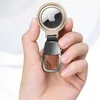 A hand holding a golden Apple AirTag case with a carabiner clip. Produktbild-Vorschau