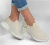 A pair of beige Skechers Slip-ins sneakers worn by a person with rolled-up jeans. Voir les images du produit