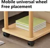 A close-up view of a two-tiered wooden side table with black wheels, featuring a stack of green and white books on the top shelf. Produktbild-Vorschau