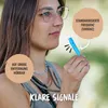 A woman is holding a blue dog whistle, with text overlays describing its features. Produktbild-Vorschau