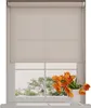 A roller blind is shown covering a window, with a vase of orange tulips on the windowsill below. Produktbild-Vorschau