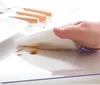A hand is wiping a transparent surface with a paper towel, showing liquid spills. Náhled obrázku produktu