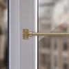 Close-up of a brass cafe curtain rod attached to a window frame. Anteprima dell’immagine prodotto