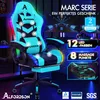 A gaming chair with LED lights and massage features, presented in a dark, futuristic setting with computer monitors in the background. Produktbild-Vorschau