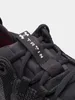 Close-up of the top of a black athletic shoe, focusing on the laces and a strap with a logo and text. Anteprima dell’immagine prodotto