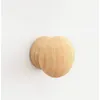 A close-up studio shot of two wooden knobs on a white wall. Produktbild-Vorschau