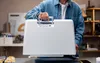 A person is holding the top handle of a white sewing machine case. Produktbild-Vorschau