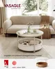 A living room scene featuring a couch and a round coffee table with storage. Produktbild-Vorschau