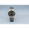 A Bering men's watch with a silver mesh strap and a dark gray dial, set against a light blue background. Produktbild-Vorschau