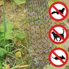 A plastic spike mat is placed on the ground with grass and dirt, surrounded by three circular warning signs indicating 'no' to cats, ferrets, and mice. Náhľad obrázku produktu