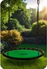 A green and black nest swing is hanging in a lush garden with trees and flowers. Podgląd zdjęcia produktu