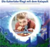 A young boy is playing a board game with a catapult mechanism, with a fantasy castle in the background. Podgląd zdjęcia produktu