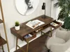 A brown wooden desk with gold legs, featuring open drawers, a book, and a plant. Voir les images du produit