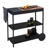 A black kitchen cart with three shelves, a wooden top with a cutting board and oranges, and a towel hanging from the side. Produktbild-Vorschau