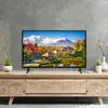 A television displaying a scenic landscape is placed on a wooden cabinet. Produktbild-Vorschau