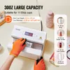 A person wearing orange gloves is using a white heat press machine to sublimate a cup. The machine has a digital display showing temperature and time. Around the machine are various cups and bottles, illustrating the product's capacity and versatility. Tex Produktbild-Vorschau