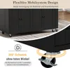 A close-up view of a black kitchen island on wheels, highlighting its mobility features. Voir les images du produit