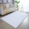 A white fluffy rug is placed in a living room setting in front of a sofa. Produktbild-Vorschau
