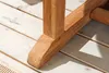 Close-up of the wooden leg of a garden table resting on a wooden deck. Produktbild-Vorschau