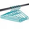 Multiple teal plastic hangers are hanging from a black rod. Anteprima dell’immagine prodotto