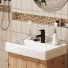 A modern bathroom sink with a black faucet and wooden cabinet. Produktbild-Vorschau