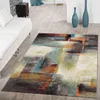 A modern living room with a white sofa and an abstract geometric rug.