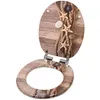 An open toilet seat with a decorative design of ropes, starfish, and stones on a wooden background. Produktbild-Vorschau