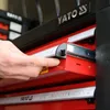 A hand is shown operating a drawer on a red and black tool chest. Produktbild-Vorschau
