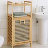 A bamboo laundry basket with shelves next to a sink and toilet in a bathroom. Podgląd zdjęcia produktu