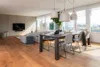 A modern living and dining area with a TV, sofa, dining table, and chairs. Anteprima dell’immagine prodotto