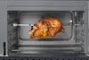 A rotisserie chicken cooking inside an oven. Náhled obrázku produktu