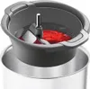 A close-up view of a food mill attachment for a kitchen appliance, with red food being processed. Produktbild-Vorschau