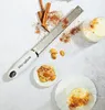 A Microplane zester is shown with ingredients like cinnamon sticks and almonds, along with grated spices and two desserts. Anteprima dell’immagine prodotto