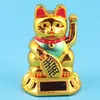 A golden Maneki-neko (lucky cat) figurine with a solar panel on its base, set against a plain blue background. Produktbild-Vorschau