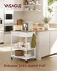 A kitchen scene featuring a rolling kitchen cart with various items on it, placed next to a kitchen island. Produktbild-Vorschau