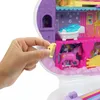 A hand is holding a small yellow comb near a toy unicorn beauty salon playset. Produktbild-Vorschau