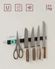 A magnetic knife holder with several knives and a pair of scissors attached. Náhled obrázku produktu
