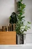 Several metallic planters and a wooden box are arranged on a white surface against a light gray and white background. Produktbild-Vorschau