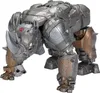 A silver and bronze rhinoceros-like robot action figure is shown from a low angle, facing forward. Anteprima dell’immagine prodotto