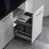 A pull-out kitchen trash bin system with multiple compartments, installed under a kitchen counter. Podgląd zdjęcia produktu