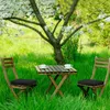 Two chairs and a table set up in a grassy garden with a blooming tree. Náhľad obrázku produktu