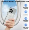 A hand holding a smartphone with a white magnetic wireless power bank attached, framed by an airplane window. Produktbild-Vorschau